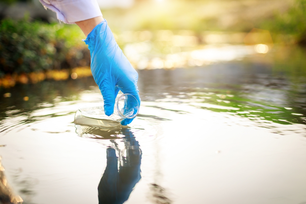  water pollution in the pond, river, lake, sea concept. The scientist takes samples of factory wastewater in a test tube. 