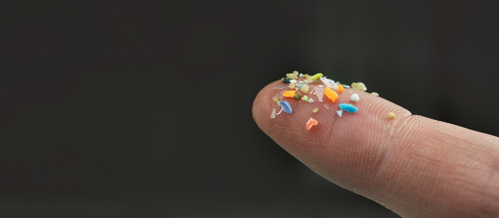 Finger holding microplastic particles