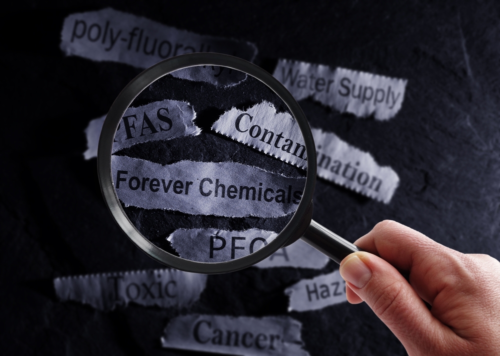 PFAS Forever Chemicals newspaper headlines and magnifying glass